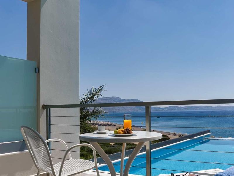 Balcone con sedie, tavolo e vista sull'oceano sotto un cielo sereno