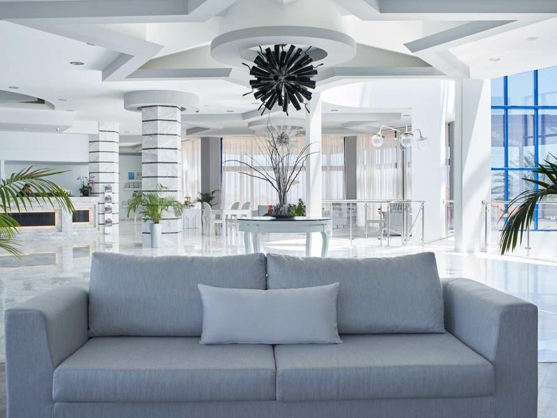 Atrio di hotel moderno con divano azzurro chiaro e design d'interni bianco elegante.