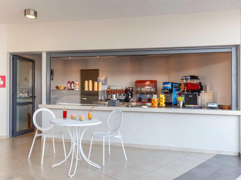 Banco bar moderno in hotel con tavolo e sedie bianche davanti