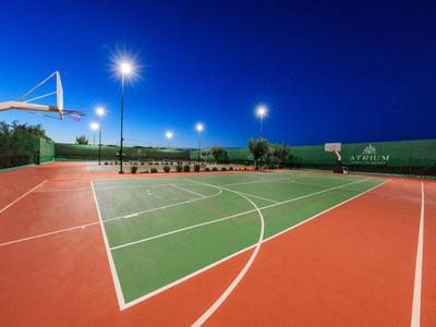 Evening view of an outdoor basketball court with floodlights and clear sky