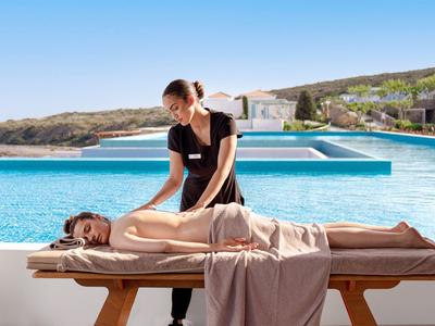 Vrouw die massage geeft bij een zwembad met uitzicht op bergen en zee