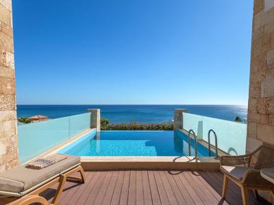 Uitzicht vanaf een terras met zwembad op de zee onder een heldere blauwe lucht