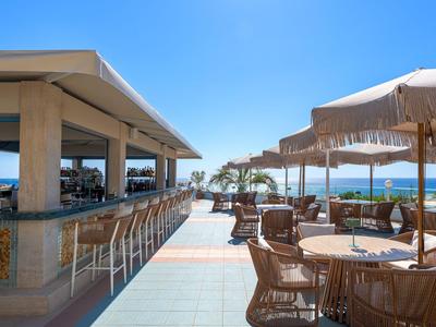 Open bar and seating area with sea view on a sunny day.