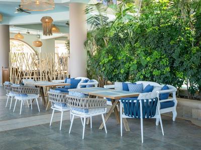 Modern lounge area with cozy chairs and green wall in a hotel.