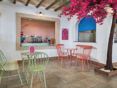Cozy seating area with pastel colors and blooming tree in a courtyard.