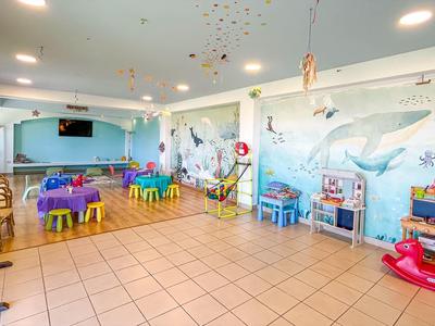 Heldere en kleurrijke kinderspeelkamer met tafels, stoelen en speelgoed in een hotel.
