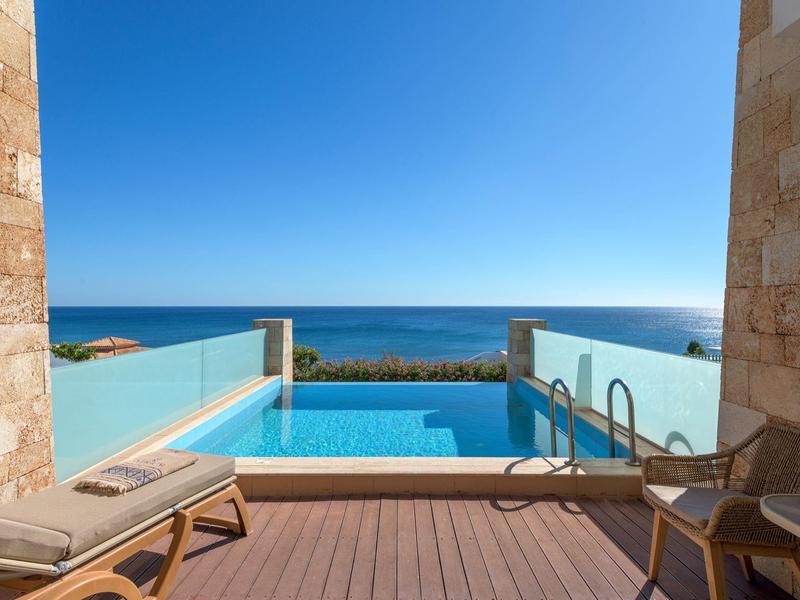 Uitzicht vanaf een terras met zwembad op de zee onder een heldere blauwe lucht
