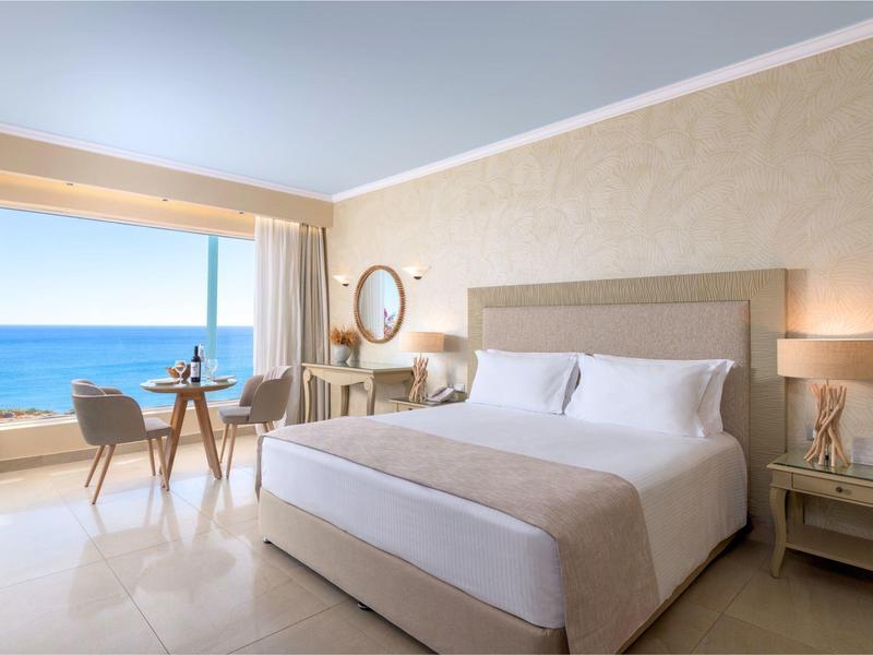 Licht ingericht hotelkamer met uitzicht op zee en balkon