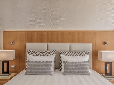 Modernes Doppelbett mit hölzernem Kopfteil und zwei Nachttischen mit Lampen