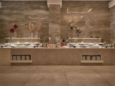 Modernes Buffet mit warmen Taupe-Tönen und dekorativen Blumen an der Wand.