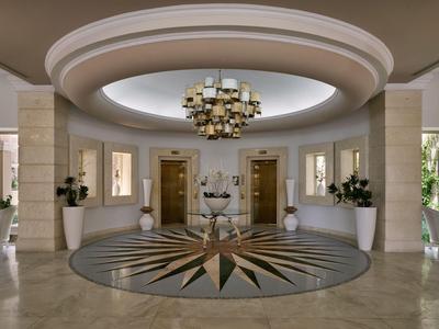 Ein eleganter Hotellobby-Eingangsbereich mit Kronleuchter und dekorativem Bodenmuster.