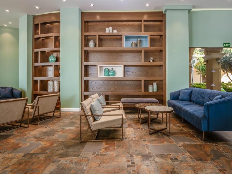 Gemütlicher Hotel-Loungebereich mit modernen Sesseln, Sofa und Holzböden.