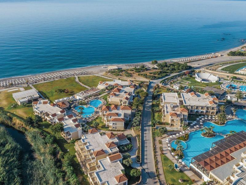 Luftaufnahme eines Resorts mit mehreren Pools und Nähe zum Meer.