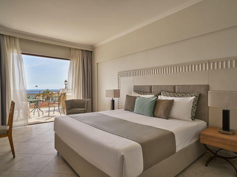 Modernes Hotelzimmer mit Doppelbett, Balkon und Meerblick.