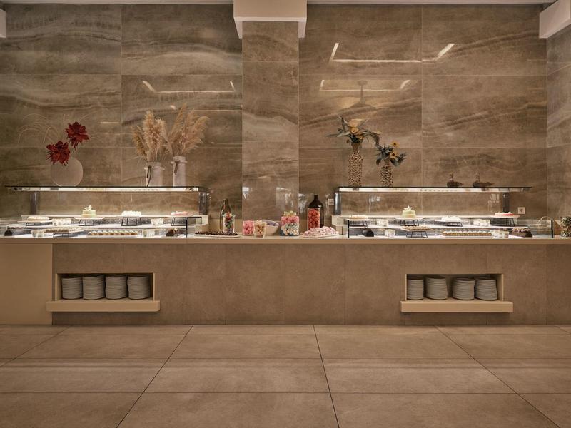 Modernes Buffet mit warmen Taupe-Tönen und dekorativen Blumen an der Wand.