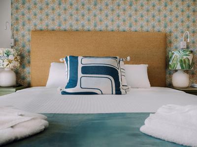 Gemütliches Hotelzimmer mit großem Bett, modernem Kissen und weichen Bademänteln.