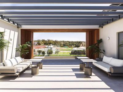 Area lounge aperta con comodi posti a sedere e vista su un campo da golf.