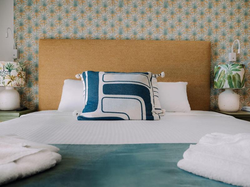 Gemütliches Hotelzimmer mit großem Bett, modernem Kissen und weichen Bademänteln.