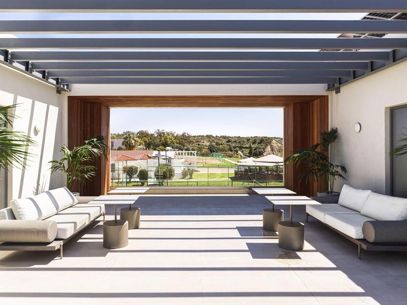 Moderner Loungebereich mit bequemen Sofas und Blick auf einen Golfplatz.