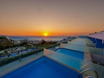 Zonsondergang met zeezicht vanaf hotelbalkons met kleine zwembaden in de avond.