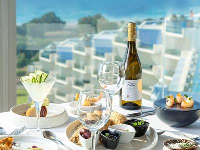 Elegant ontbijt met wijn en zeezicht op een terras.