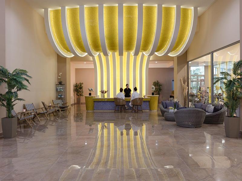 Moderne hotel lobby met gele designerverlichting en marmeren vloer