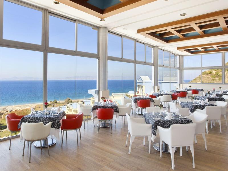 Modern restaurant met panoramische ramen met uitzicht op zee en strand.