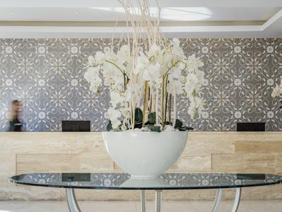 Elegante Hotellobby mit Blumentopf und stilvoller Rezeption im Hintergrund