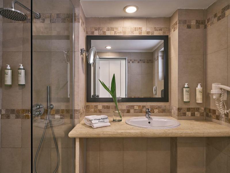 Modernes Badezimmer mit großem Spiegel, Waschbecken und Dusche in einem Hotelzimmer.