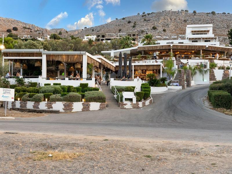 Due ristoranti affiancati con edifici bianchi e aree coperte lungo una strada di montagna.