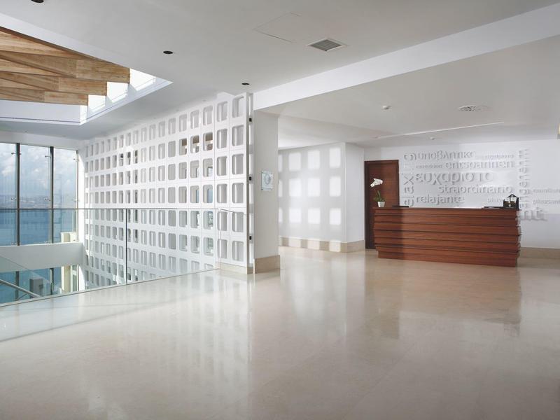 Helle, moderne Hotellobby mit glattem Boden, Holzdecke und Rezeptionstresen.