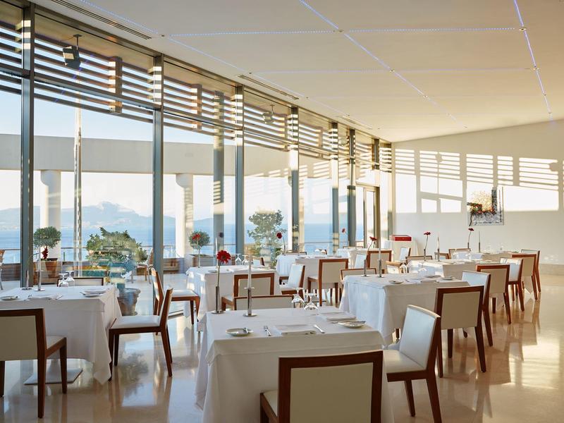 Modernes, helles Restaurant mit großen Fenstern und Blick auf das Wasser.