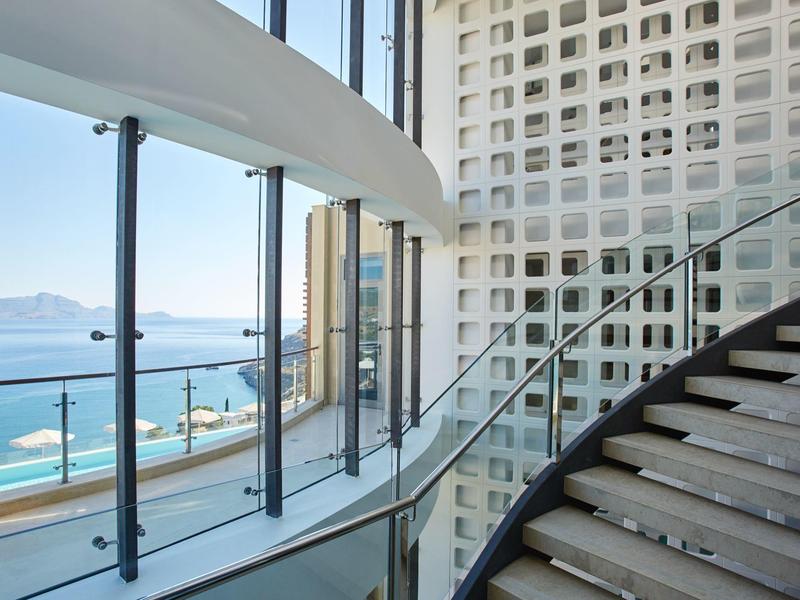 Moderne Treppe mit Glasgeländer und Meerblick durch großflächige Fenster