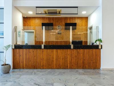 Moderne hotelreceptie met houten bekleding, zwarte balie en beschermschermen.