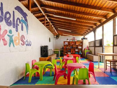 Sala giochi colorata con piccoli tavoli e sedie in un'area bambini di un hotel.