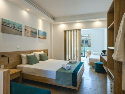 Camera d'hotel moderna con letto matrimoniale, mobili in legno e accesso al balcone.