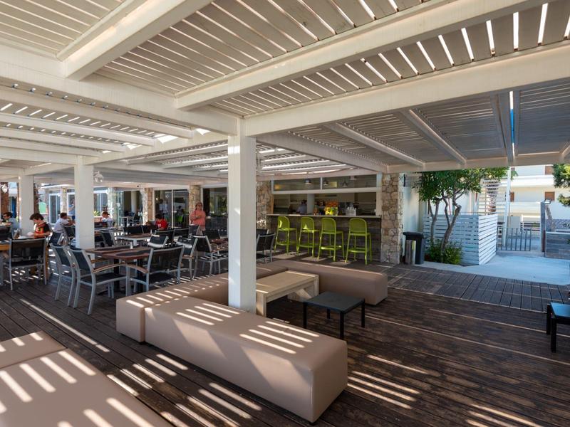 Überdachte Terrasse mit Sitzbereichen und moderner Beleuchtung in einem Hotel