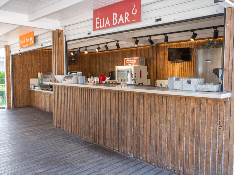 Moderner Holzbarbereich mit Kaffeemaschine und Getränken in einem Restaurant oder Hotel.