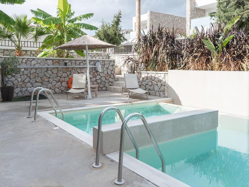 Poolbereich mit Treppen, Liegestühlen und Sonnenschirm in einer modernen Außenanlage.