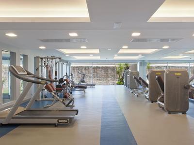 Moderne Fitnessstudio mit Laufbändern und Kraftgeräten in hell beleuchtetem Raum.