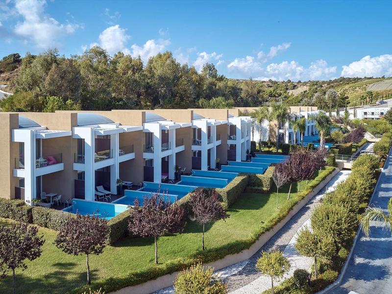 Modern townhouses with private pools in a green, sunny holiday resort.