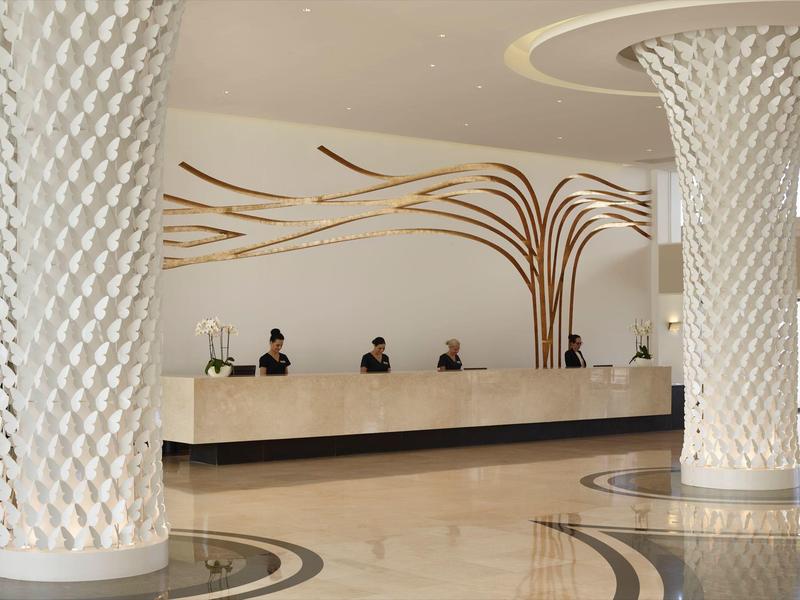 Modern hotel reception with elegant columns and curved wall design.