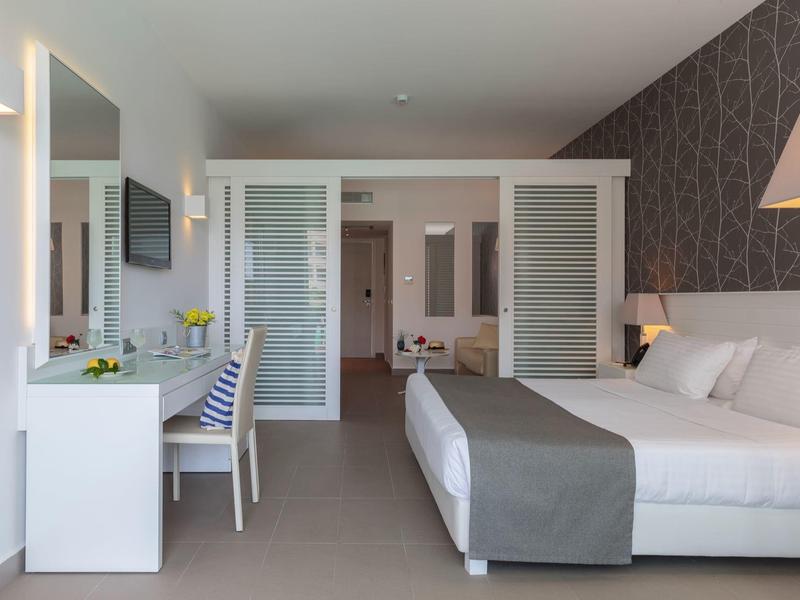 Modern hotel room with double bed, desk, and cozy lighting.