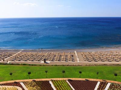 Spiaggia con molti ombrelloni di fronte a un mare calmo sotto un cielo sereno.