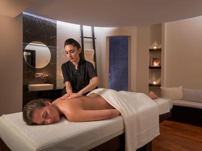 Una donna riceve un massaggio in una stanza spa elegante e accogliente.