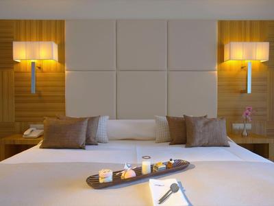 Schlafzimmer mit großem Bett, zwei Nachttischen und Wandlampen, ideal fürs Hotel.