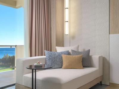 Modern eingerichteter Hotelbalkon mit gemütlichem Sofa, Kissen und Blick aufs Meer.