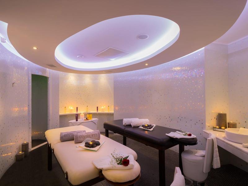 Spa moderno con illuminazione soffusa, lettini da massaggio e atmosfera rilassante.