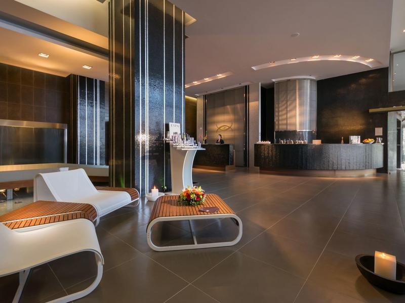 Reception di hotel moderna con poltrone bianche e arredi scuri ed eleganti.