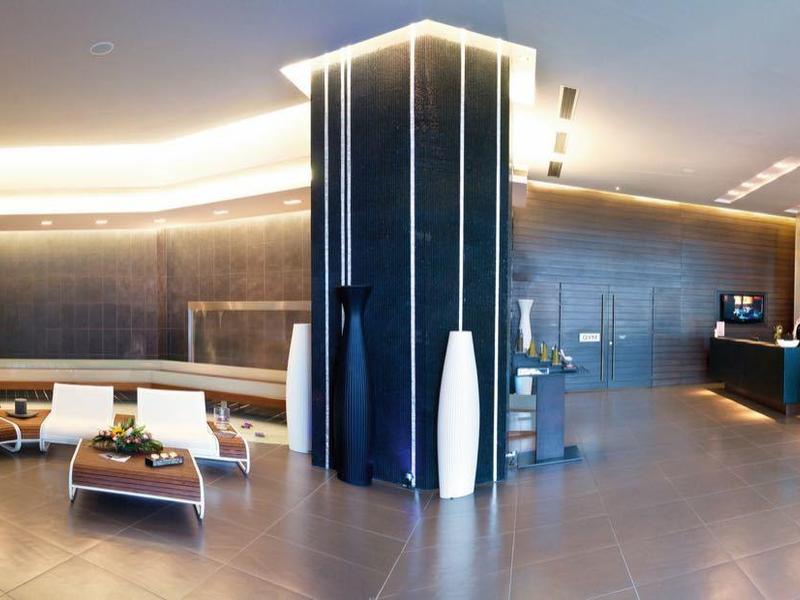 Interno moderno di un hotel con reception elegante e area salotto illuminata.